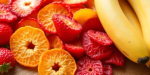 Colorful freeze-dried fruits on a wooden surface.